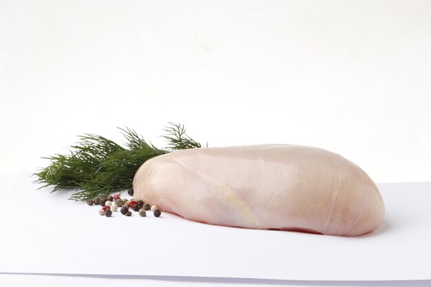 rohes Hähnchenfilet mit Dill und Pfeffer auf weißem Hintergrund