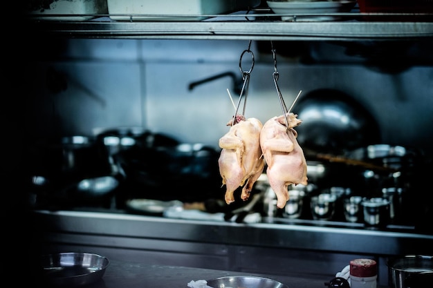 Foto rohes hühnerfleisch hängt in der küche zu hause