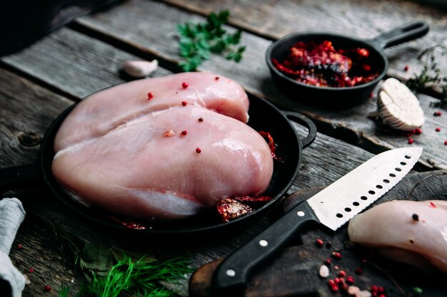 Rohes Huhn auf einem Holztisch mit Gewürzen