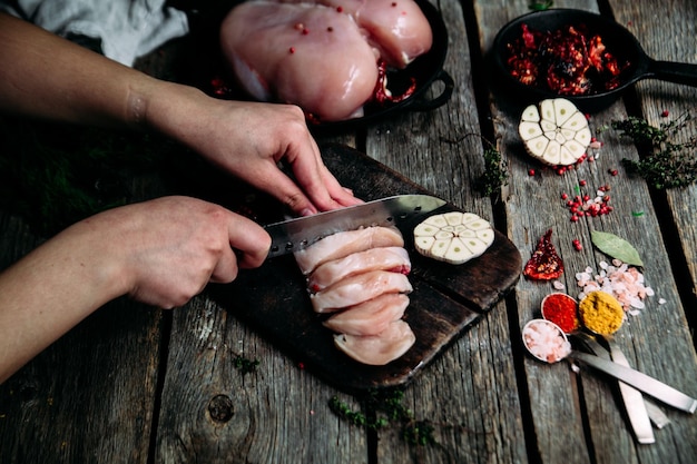 Rohes Huhn auf einem Holztisch mit Gewürzen