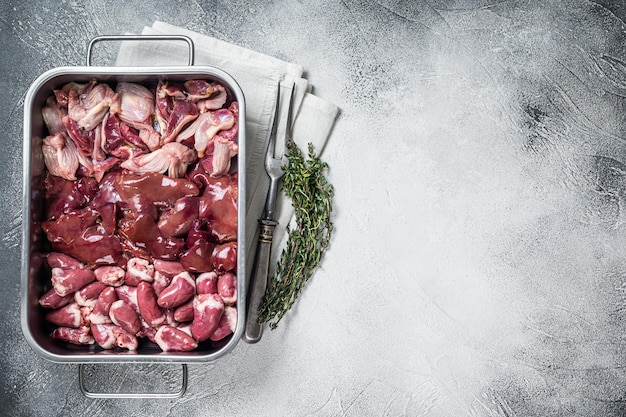 Rohes huhn innereien fleisch set muskelmagen mägen leber und herzen in einem stahlblech mit kräutern weißer hintergrund ansicht von oben kopieren sie platz