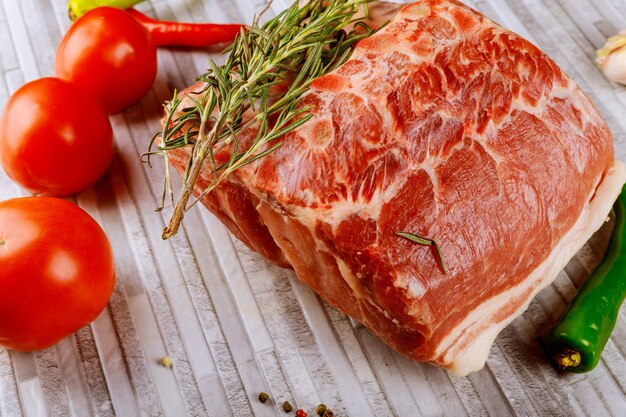 Rohes Kalbfleischfleisch mit frischen Schweinefleischrippen mit Gewürzen und Gemüse auf Küchentisch