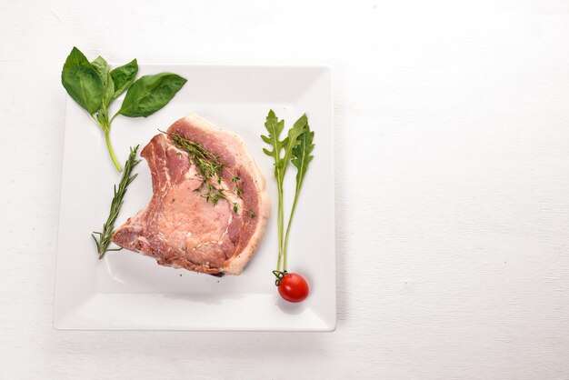 Rohes Kalbssteak auf einem Teller Auf einem hölzernen Hintergrund Ansicht von oben Freier Platz für Text