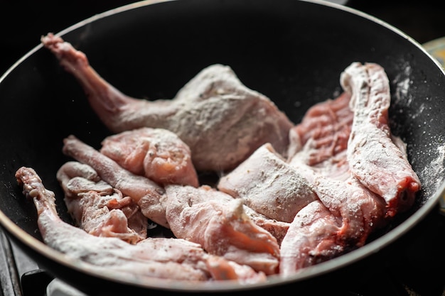 Rohes Kaninchen in einer Pfanne Geschmortes Kaninchen kochen