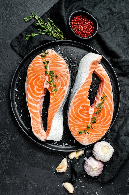 Rohes Lachssteak auf einer Platte mit Gewürzen. Atlantischer Fisch. Ansicht von oben