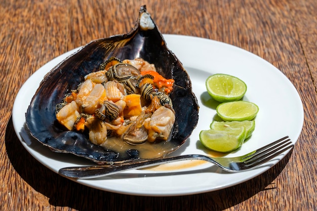 Rohes Muschelfleisch in einer großen Muschel serviert zum Essen in einem lokalen Restaurant auf der Insel Sansibar Tansania Ostafrika