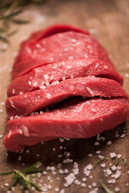 Rohes Rindersteak auf einem dunklen Holztisch.