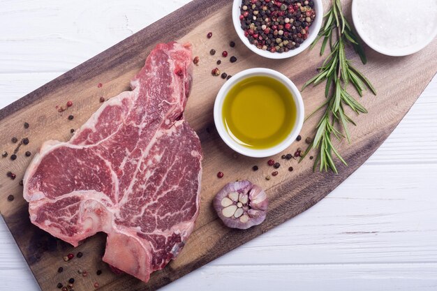 Rohes Rindersteak T-Bone mit Zutat Porterhouse auf Schneidebrett