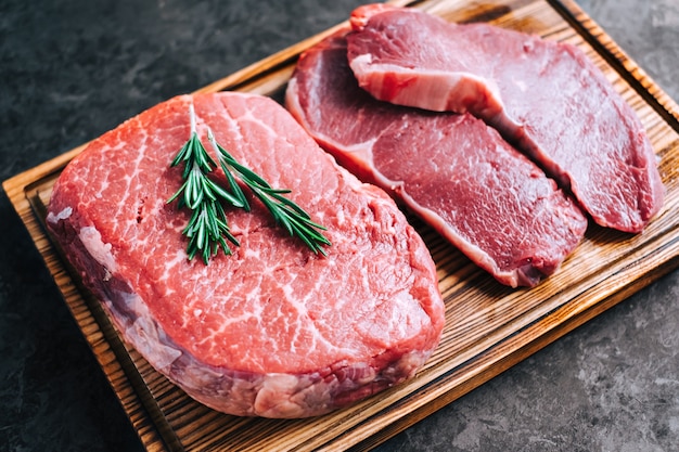 Rohes Rindersteak und Entrecote auf Holzbrett Nahaufnahme