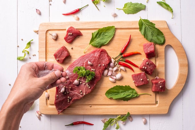 Rohes Rindfleisch auf weißem hölzernem Hintergrund