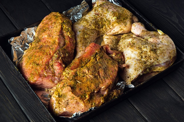 Rohes Rindfleisch und Hähnchenschenkel auf einem Backblech werden zum Backen im Ofen vorbereitet. Das nationale Fleischgericht wird am Vorabend der Feiertage zubereitet.