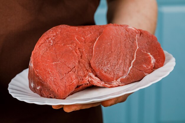Rohes Rindfleisch zum Kochen von Steak auf einem weißen Teller