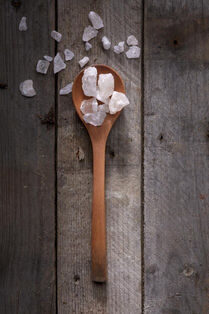 Rohes Salz auf altem Tisch mit Holzlöffel