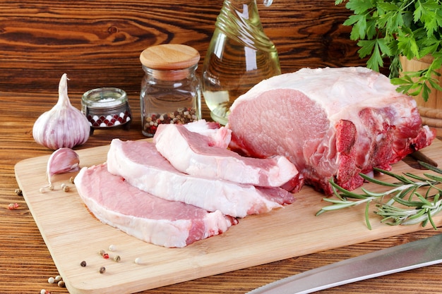 Foto rohes schweinefilet auf einem schneidebrett, in steaks geschnitten