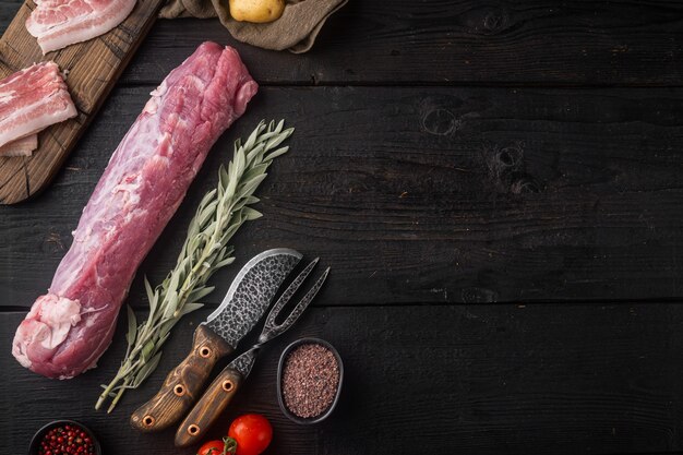 Rohes Schweinefilet mit Salbei-Set, auf schwarzem Holztisch