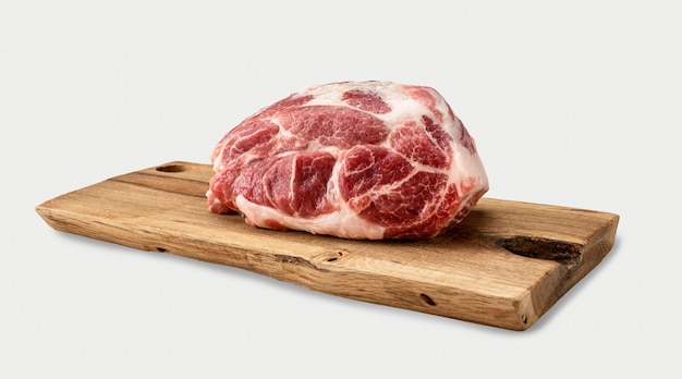 Rohes Schweinefleisch auf Holzbrett. Rohes Fleisch. Rohes Schweinefleisch - Hals oder Bauch. Frisches Fleisch auf Schneidebrett. Stück rohes Lammfleisch. Metzgerei, Markt. isoliert auf weißem Hintergrund