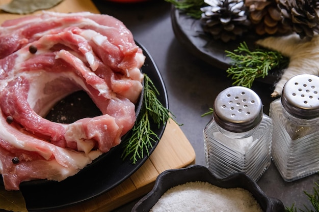 Rohes Schweinefleisch in Scheiben geschnitten für die Zubereitung eines Abendessens für ein Weihnachtsgericht mit Weihnachtsdekoration