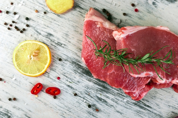 Rohes Schweinefleisch mit Gewürzbestandteil - Rosmarin, Ingwer, Paprikapfeffer, Zwiebel. Ansicht von oben. Flach liegen. Kopieren Sie Platz.