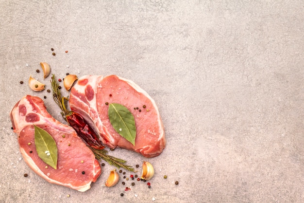 Rohes schweinefleischsteak mit gewürzen und getrockneten kräutern