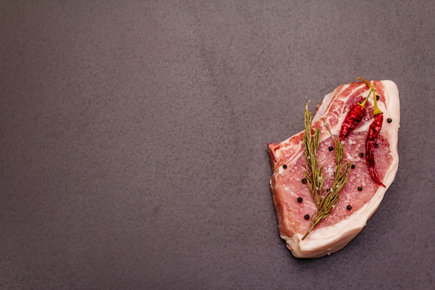 Rohes Schweinesteak auf grauem Tisch