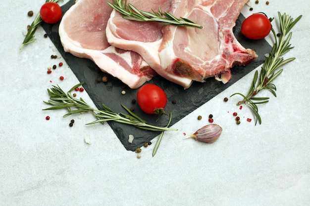 Rohes Schweinesteak auf Knochen auf heller Oberfläche