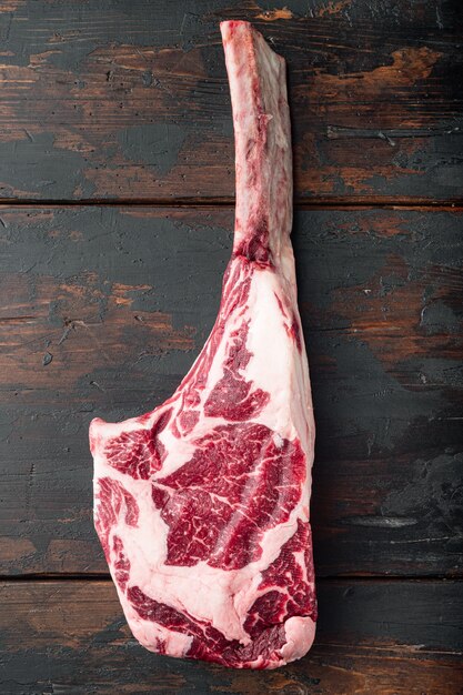 Rohes Set Tomahawk Beef Steak, auf altem dunklem Holztisch Tisch, Draufsicht flach legen