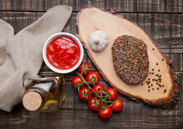 Rohes Steak des Rindfleisches mit Pfeffer und Tomaten auf Steinbrett