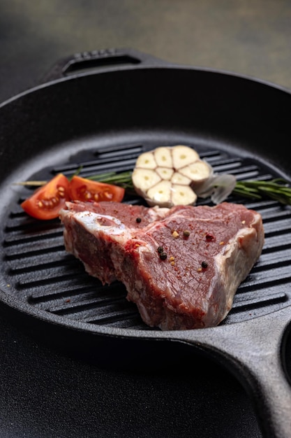 rohes Steak mit Gewürzen in einer gusseisernen Pfanne