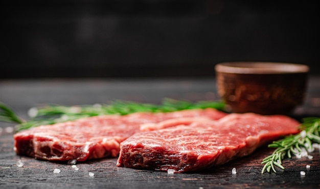 Rohes Steak mit Rosmarin und Gewürzen auf dem Tisch