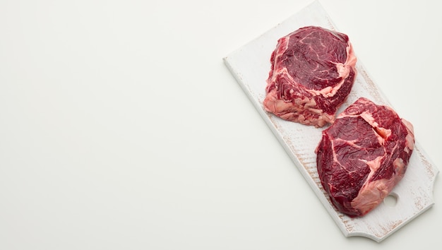 Rohes Stück Rindfleisch Ribeye auf weißem Hintergrund, Textfreiraum