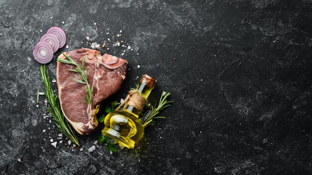 Rohes Tbone-Steak auf einem schwarzen Steintisch Draufsicht Freier Platz für Ihren Text