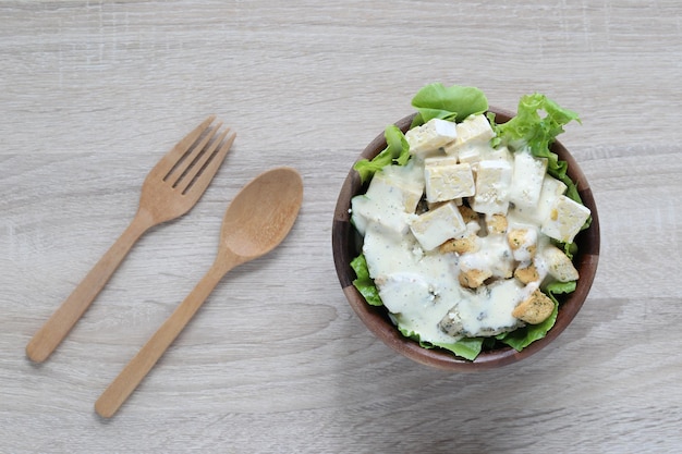 Rohes Tempeh Draufsicht auf Kichererbsen-Tempeh und Salat in einer Schüssel auf Holzhintergrund Konzept für gesunde Ernährung