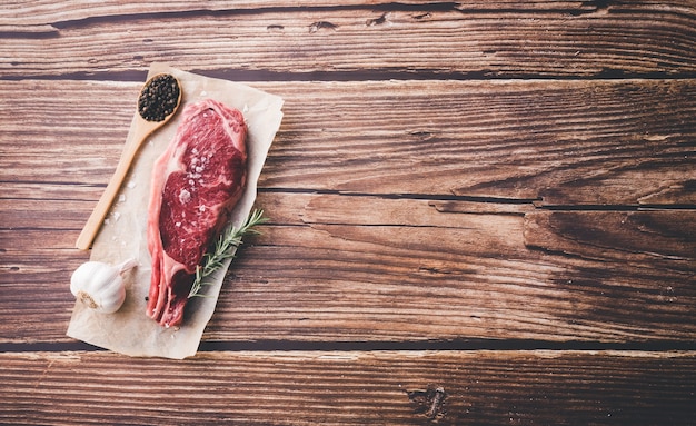 Rohes trockenes gealtertes Steakrindfleisch auf Holztisch. Speicherplatz kopieren