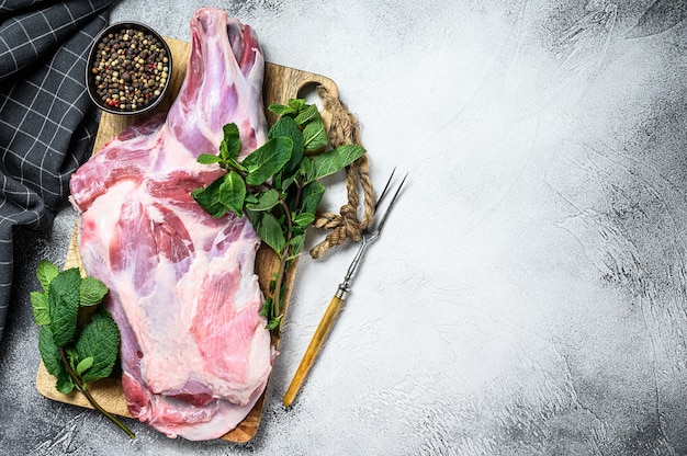 Rohes Ziegenschulterfleisch bereit zum Backen mit Knoblauch, Minze