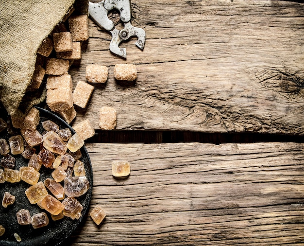 Foto rohrzucker auf holztisch. draufsicht