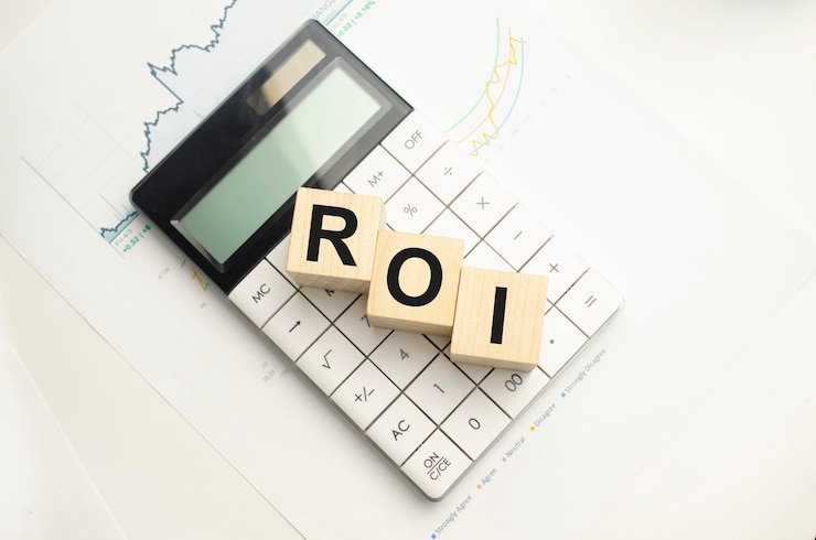 ROI Retorno do investimento escrito em cubos de madeira entre calculadora e caneta sobre fundo claro Conceito de investimento Foto de alta qualidade