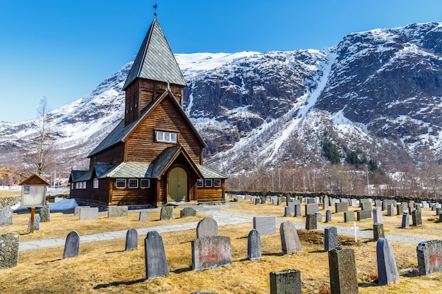 Roldal Stave Church (Roldal stavkyrkje) com fundo de montanha de boné de neve