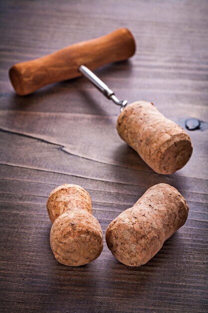Rolhas de champanhe e saca-rolhas no conceito de álcool de placa de madeira vintage