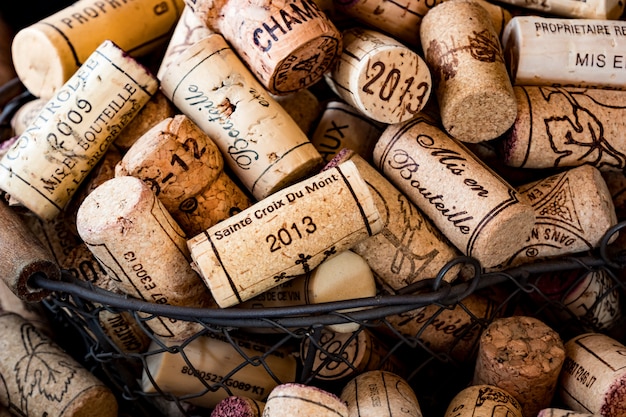 Rolhas de cortiça velha de vinhos franceses em uma cesta de arame