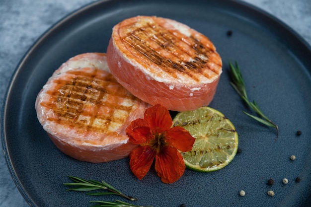 Rolinho de salmão grelhado com mussarela decorado com lima verde e flor comestível