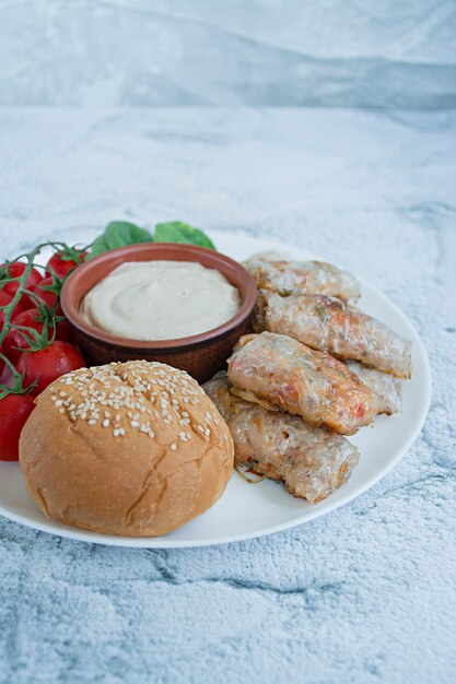 Rolinho primavera com carne e legumes, servido em um prato branco com molho.