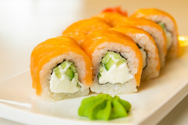 Rolinhos com salmão e pepino, queijo e wasabi em um prato