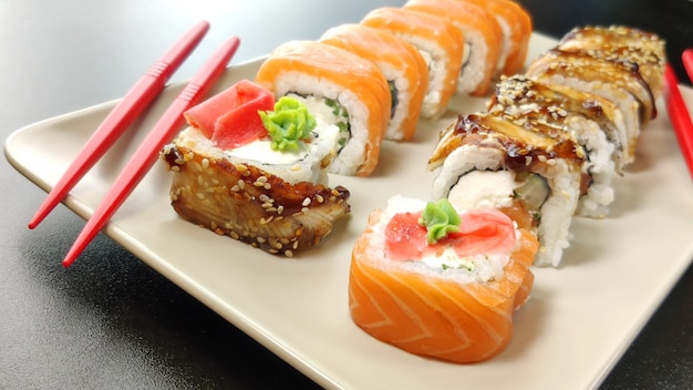 Foto rolinhos de sushi com salmão e pauzinhos