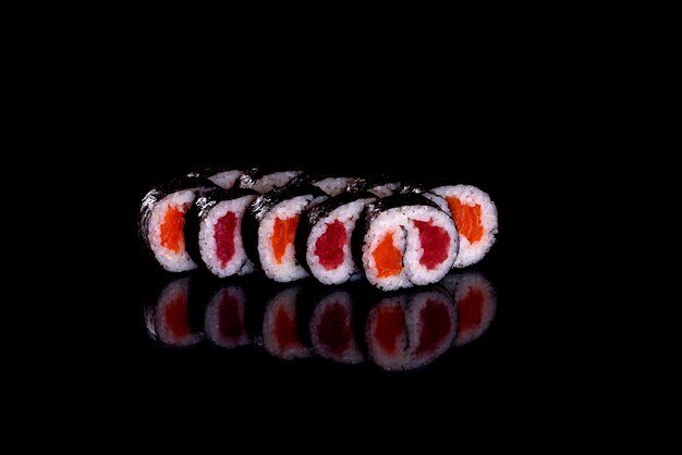 Rolinhos de sushi frescos e deliciosos em um fundo escuro