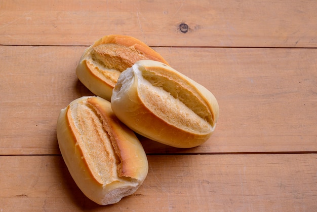 Rolinhos franceses. Pães brasileiros na mesa de madeira.