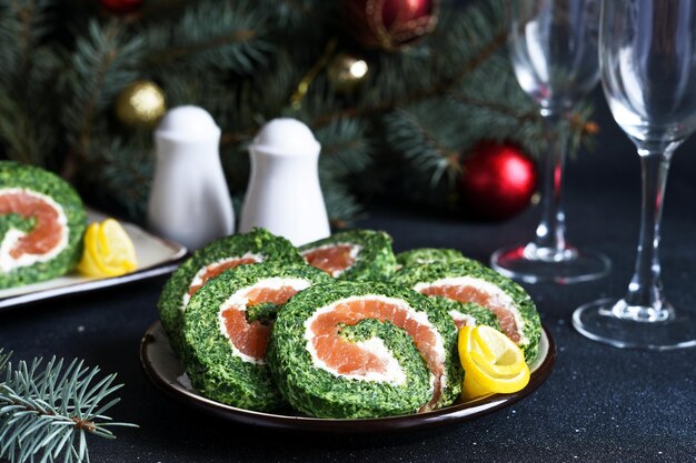 Roll con espinacas en la mesa de Año Nuevo. Aperitivo de queso y salmón.