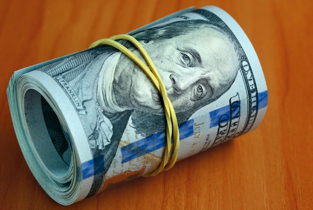 Rolle von Dollarnoten auf einem Tisch - Geld schweigt Konzept