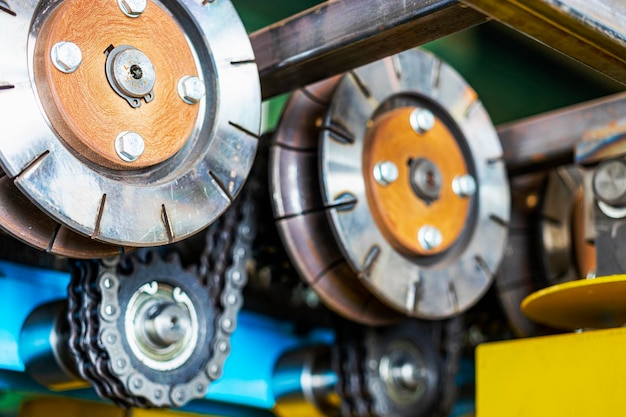 Rollen einer Industriemaschine zum Schneiden von Metall mit Kettengetriebe Förderlinie in einer Fabrik zur Verarbeitung von Stahlblechen Nahaufnahme von Produktionsanlagen