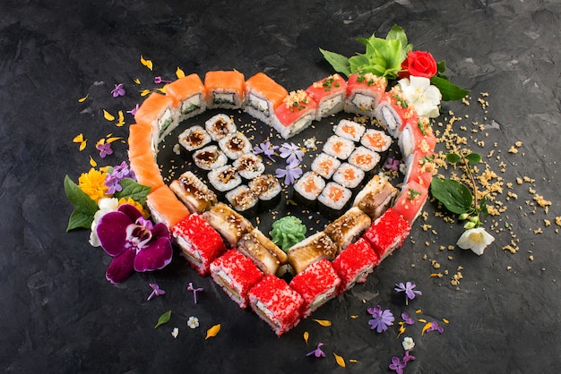 Rollen und Sushi auf einem schwarzen Schieferhintergrund, japanische Küche
