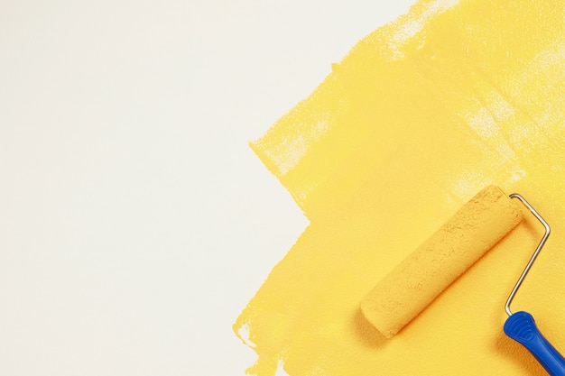 Roller Brush Painting, Arbeiter Malerei auf Oberflächenwand Malerei Wohnung, Renovierung mit gelber Farbe.